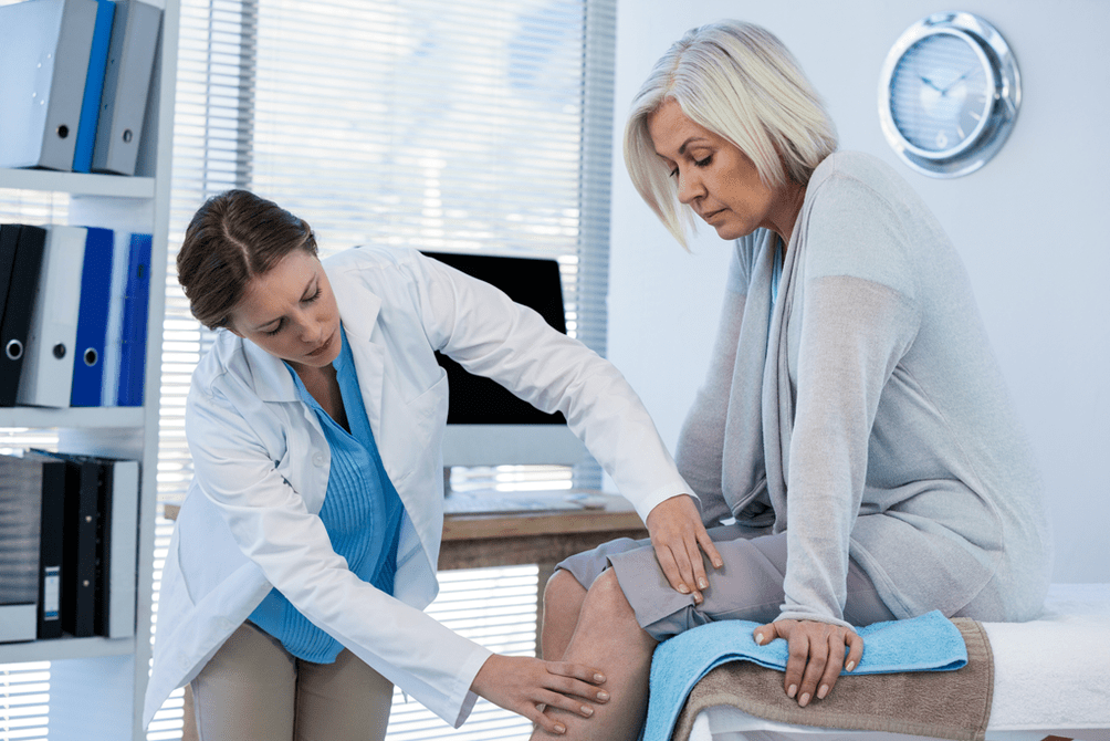 Der Arzt untersucht einen Patienten mit Arthrose des Kniegelenks